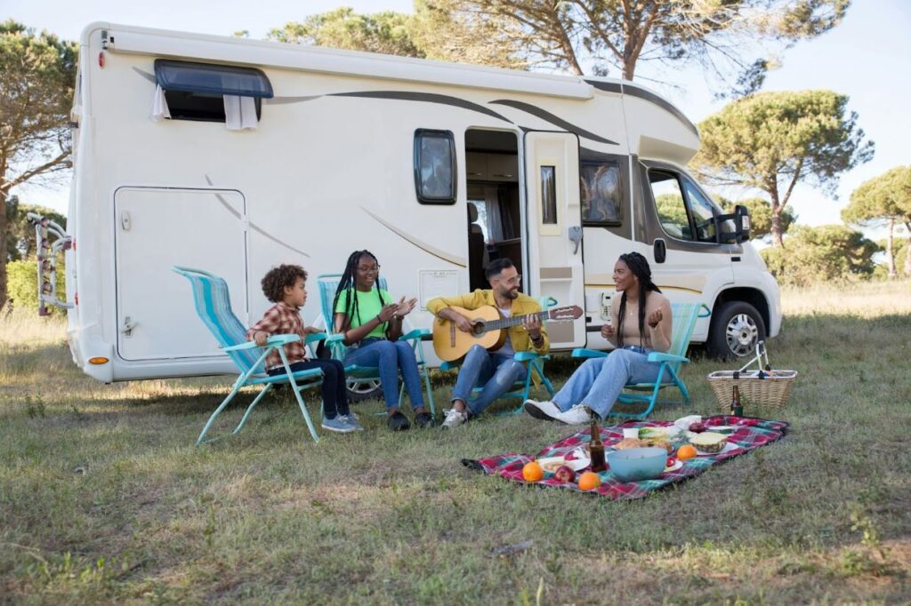 a family sits outside their trailer singing songs and eating snacks