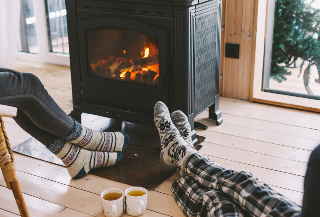 A fireplace with two people cozying up by it