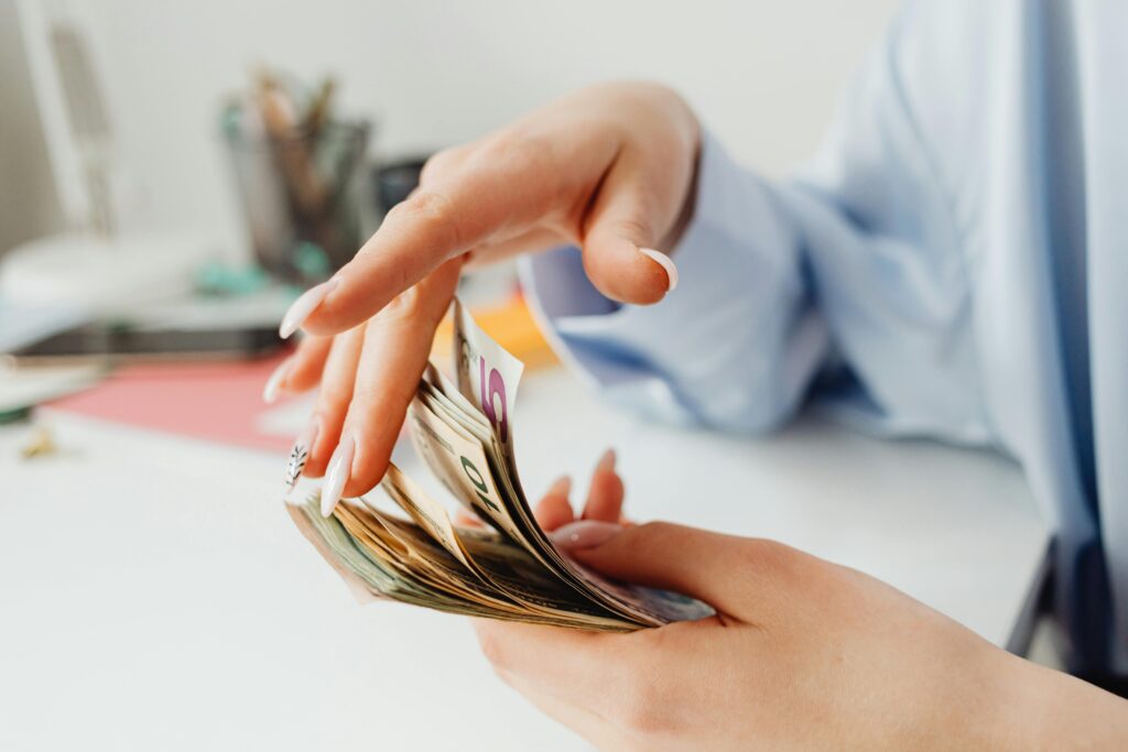 A closeup of a woman's hands counting money