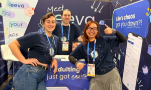 the eeva team poses with thumbs up in front of the eeva booth at CES