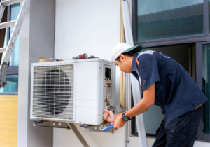 main repairing AC unit at window of home